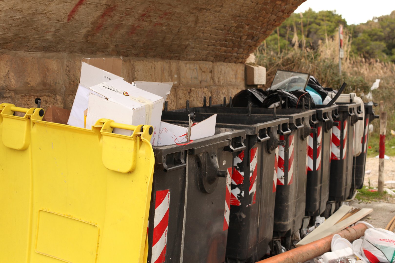 Garbage bins overflowing angled view